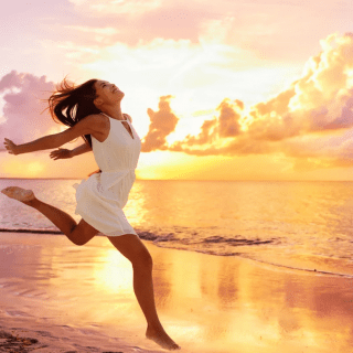 Девушка бежит по пляжу на фоне заката